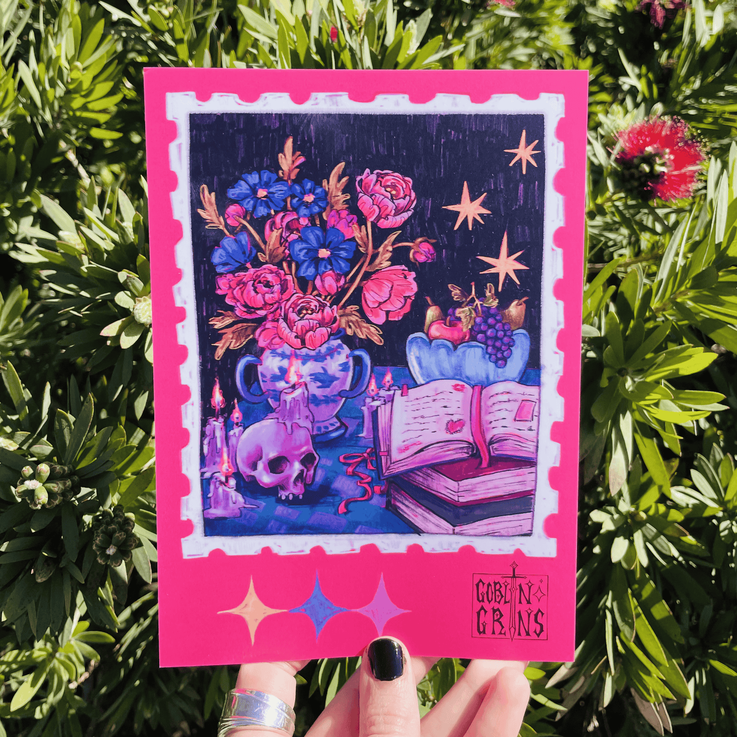 Colorful card with fantasy design held against a green leafy background